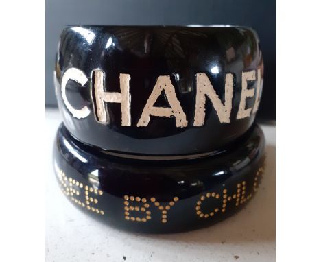 Jessica Kagan Cushman and Chloe-A small 'Ripped Off By Chanel' black bangle with cream inscription, signed by the designer to