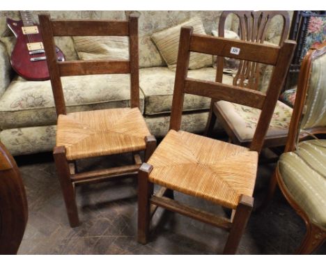 Pair of oak ladder back rush seat dining chairs 