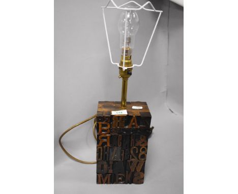 A modern side lamp having a printers block base.