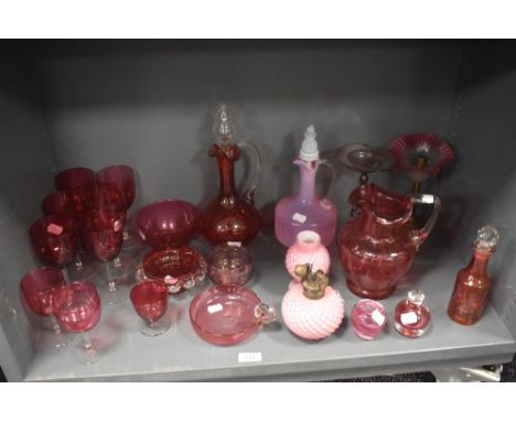 A fine selection of Victorian and later cranberry and ruby glass wares including, wine glasses, decanter, water jug, oil lamp
