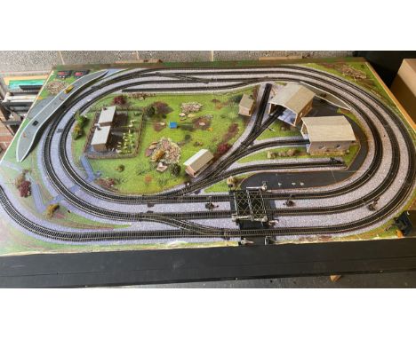 Table top model train layout with buildings and accessories, this measures approximately Length 72 inches, Width 50 inches