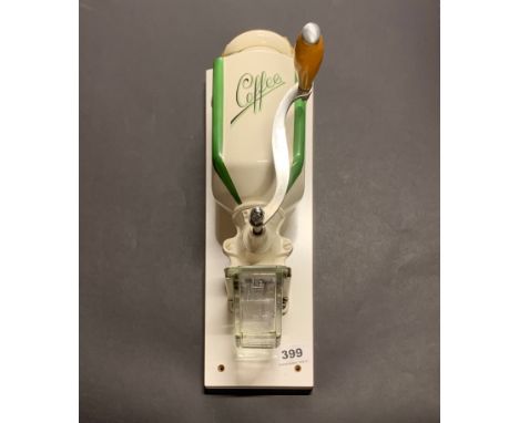 A vintage wall mounted coffee grinder.