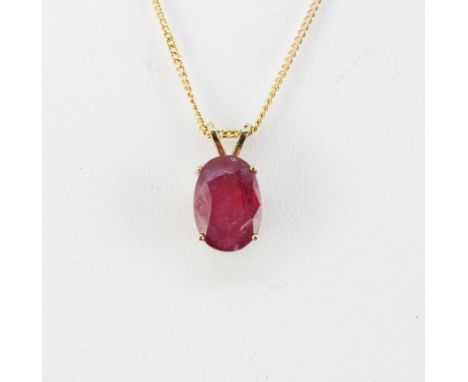 A yellow metal pendant (tested minimum 9ct gold) set with a large oval cut ruby L. 1.5cm, on a 9ct yellow gold chain, L. 46cm