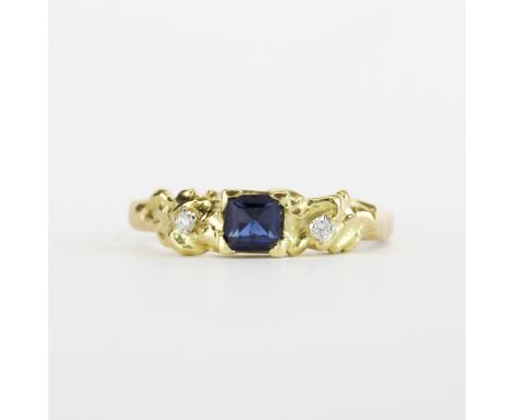 A hallmarked 18ct yellow gold ring set with a princess cut sapphire and diamonds, (R ).