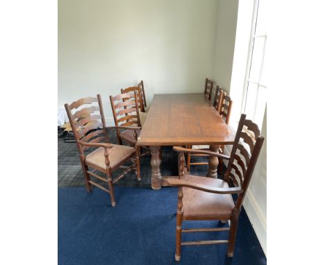 A large oak refectory table with a set of eight ladder back chairs with leather upholstery, 215 x 91cm.