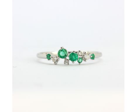 An 18ct white gold ring set with round cut emeralds and brilliant cut diamonds, (M.5).