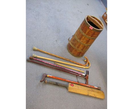 A vintage barrel stick stand and contents to include a cricket bat 