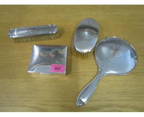 A silver backed dressing table hand mirror and matching brush, another hairbrush, and a silver cigarette box with presentatio