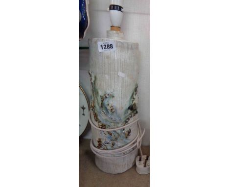A studio pottery lamp with abstract floral sprays on a textured ground
