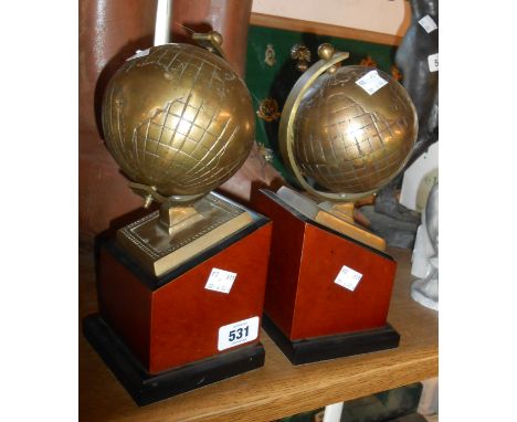 A pair of vintage brass globe bookends set on wooden plinths