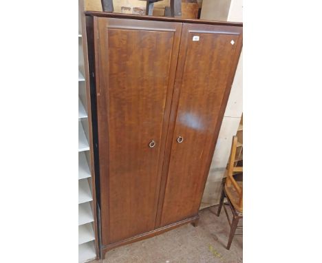 A 97cm Stag Minstrel wardrobe with hanging space, slides and shelves enclosed by a pair of moulded doors, set on bracket base
