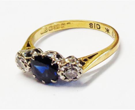 An 18ct. gold ring, set with small central dark sapphire with flanking illusion set diamonds - size K 1/2 - boxed