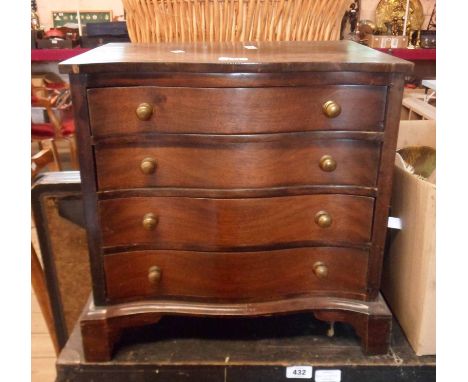 A 44.5cm 20th Century mahogany and cross banded small serpentine front chest of four long graduated drawers, set on bracket f