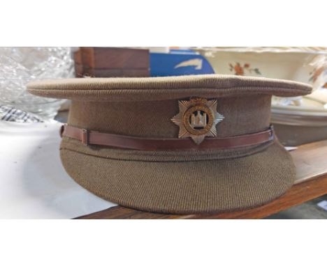 A WWII Devonshire Regiment officer's cap, a similar period RAF officer's cap and an English pattern helmet with sand finish a