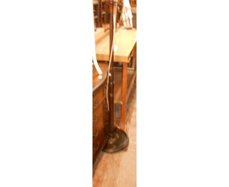 An old mahogany standard lamp with metal top stem and lead loaded circular base, set on squat bun feet