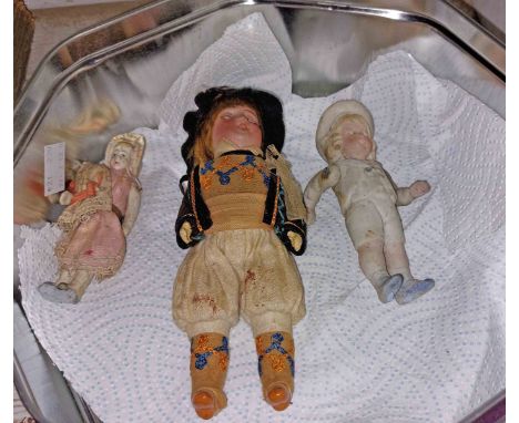 An antique miniature bisque porcelain doll holding a baby - sold with a sailor boy similar and a later costume doll