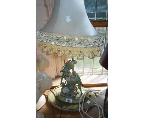 A vintage table lamp with painted bisque ceramic budgerigar group, set on velvet covered base with original shade