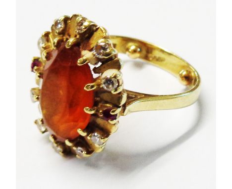 A marked 585 (14ct.) yellow metal ring, set with large central orange fire opal within a diamond punctuated radial border wit