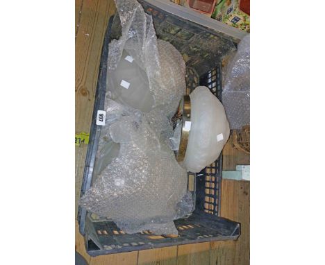 A crate containing a set of three opaque glass hanging ceiling lamp shades with brass fittings