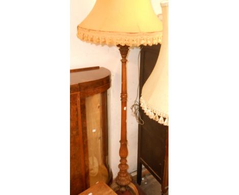 An ornate carved wood standard lamp, set on an acanthus tripod base