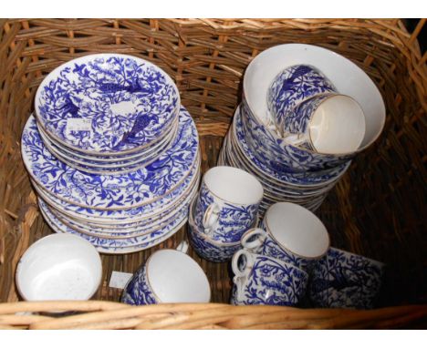 An old wicker hamper containing a quantity of Royal Crown Derby blue and white decorated china