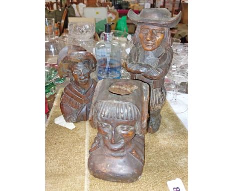 Three antique carved wood figurines comprising a figural candlestick depicting a man wearing clogs, a similar depicting a fem