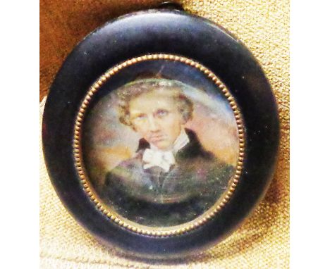 A late 19th Century ebonised and brass beaded framed portrait miniature, depicting a gentleman - 7cm oval