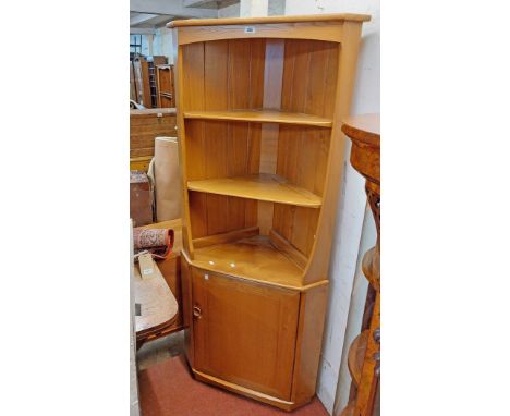 A 75cm Ercol 743C light elm freestanding corner cupboard with three open shelves over a cupboard door enclosing futher shelve