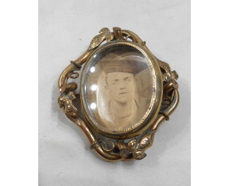 A late Victorian ornate gilt metal swivel brooch with photographic portrait of a sailor to front