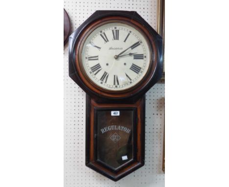 An old American part ebonised and stained cased drop dial wall clock with visible pendulum and Ansonia bell striking movement