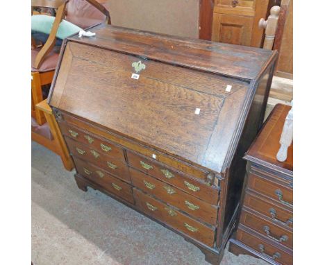 A 1.03m antique oak bureau with fitted interior and two flights of three drawers under, set on bracket feet - glazed top miss