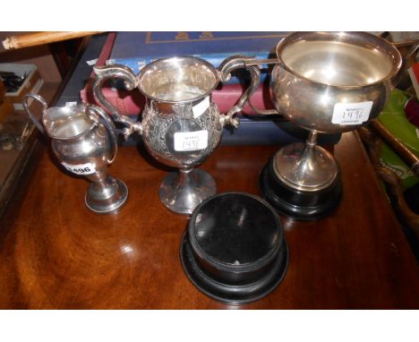 Three silver plated trophy cups including one on an ebonised wood socle, also another socle