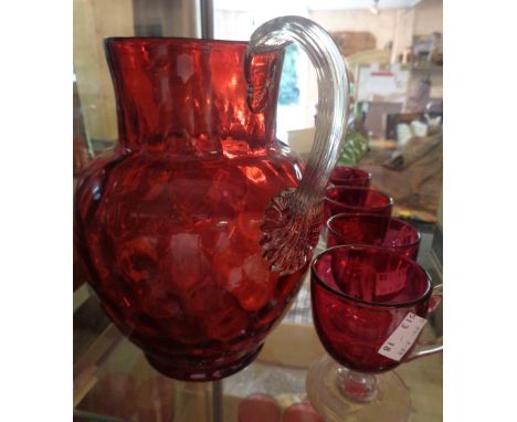 A ruby glass jug with applied celery form handle - sold with a set of six cranberry glass custard cups