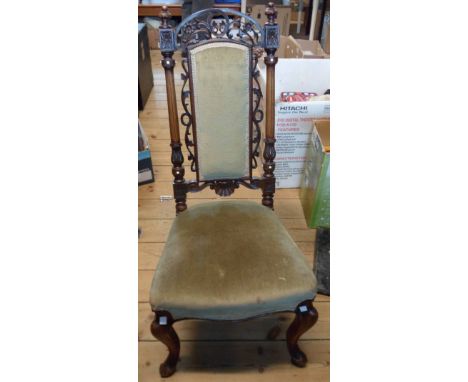 A Victorian walnut framed high panel back Baronial style standard chair with ornate carved and pirced decoration, upholstered