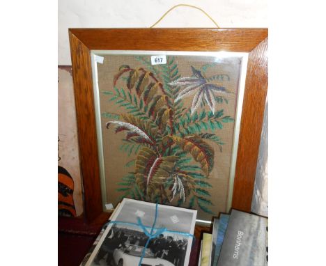 A polished oak framed Berlin woolwork panel depicting foliage - sold with an old embroidery panel depicting a garden arch sur