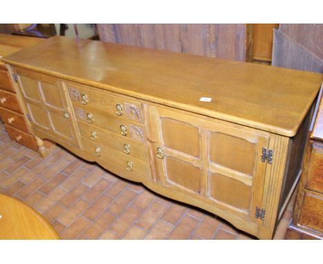 LONG JOHN SIDEBOARD. Light oak Long John sideboard with side by side cupboard and four central drawers with carved detail, L 