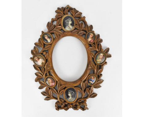 A 19th century European carved wood picture frame, possibly German, inset with eight painted miniatures of women, the frame w