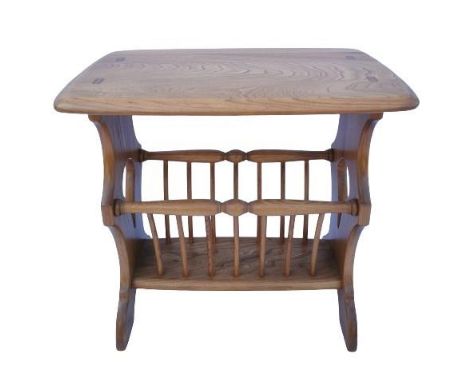 A light elm Ercol magazine rack, having rectangular top over magazine rack with slanted spindles and shaped supports, 50 cm h