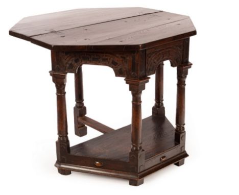 A mid 17th Century oak credence table, probably Somerset, on bold column supports, with applied blind fretwork to arched span