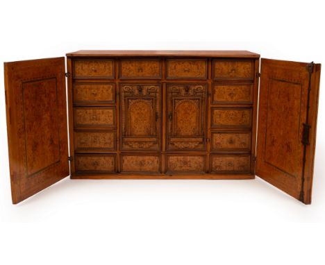 A late 16th Century Augsburg marquetry table cabinet, with two cupboard doors enclosing fourteen various sized drawers framin