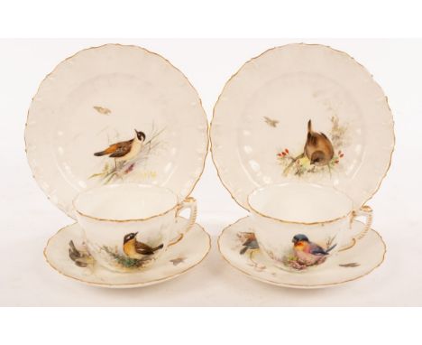 A pair of tea cups and saucers painted birds in foliage with gilt scrolling borders, Rd No 190547, W5529 and two tea plates, 