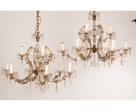 A pair of glass nine-light chandeliers with three upper lights above six lower, the drip trays hung with glass drops, 77cm di