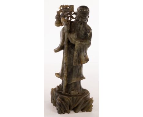 A Chinese jade figure of Shoulao, early 20th Century, standing on a plinth, a peach in his left hand and a walking stick in h