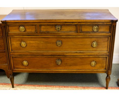 A French provincial walnut commode, fitted three graduated drawers flanked by fluted columns on peg feet, 125cm wide, 54cm de