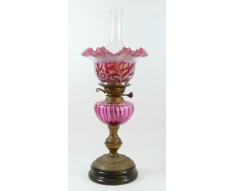 A late Victorian oil lamp, with etched cranberry glass shade, floral decoration, clear glass chimney, cut glass cranberry oil