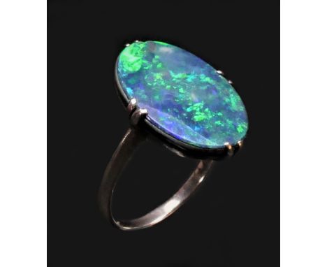 A white metal mounted black opal doublet ring, c.1920/30, the oval stone with good colour play, 18 x 13mm, I 1/2. 