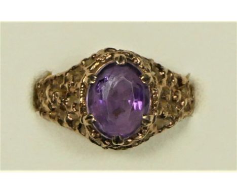 A 9ct rose gold amethyst vintage dress ring, claw set with a mixed cut stone to a bark finish shank, L, 3.8gm 