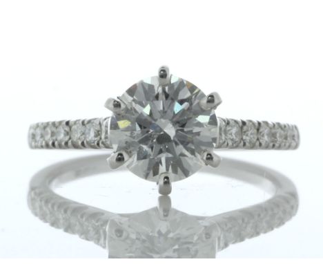 A gorgeous natural round brilliant cut diamond 1.56 carats is set with fourteen diamonds on the shoulders of this with 18ct w