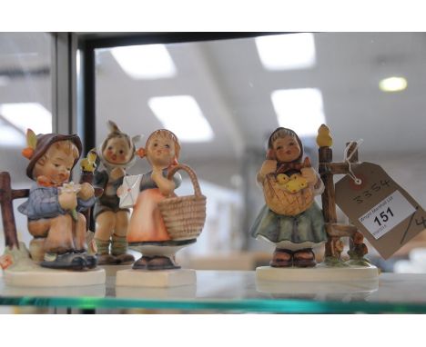 Four Hummel figures including a girl holding chicks in  a scarf.