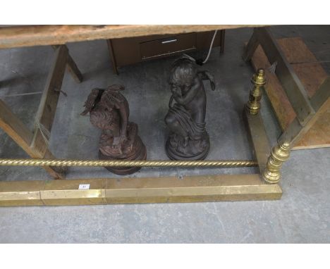 A Brass fender and 2 composition cherub figures.
